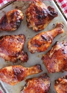 Baked BBQ chicken legs and thighs served on a plate with sauce