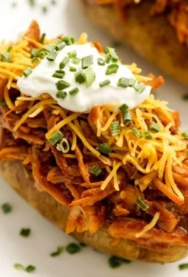 Baked potato topped with BBQ shredded chicken garnished with green onions