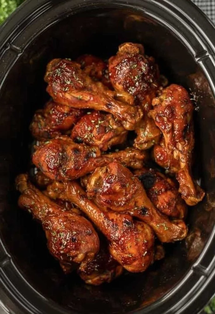 Delicious BBQ chicken legs made in a crock pot, served on a plate.