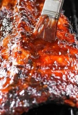 Delicious grilled ribs on a platter, garnished with herbs and BBQ sauce.
