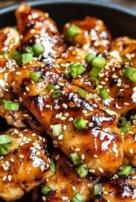 Deliciously cooked Korean chicken breasts garnished with sesame seeds and green onions.