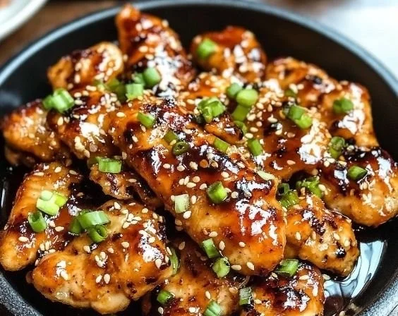 Deliciously cooked Korean chicken breasts garnished with sesame seeds and green onions.