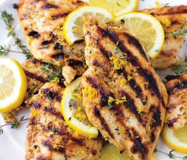 Delicious lemon marinade for chicken in a bowl with fresh herbs