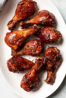 Crispy oven baked chicken legs served on a plate with herbs