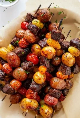Delicious grilled steak kabobs on skewers with colorful veggies