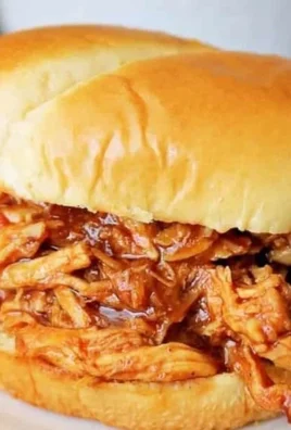 Delicious Crockpot BBQ chicken served on a plate with sauce and garnishes