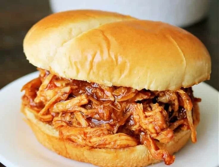 Delicious Crockpot BBQ chicken served on a plate with sauce and garnishes