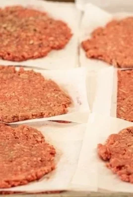 Delicious homemade smash burger with toppings and buns on a wooden board