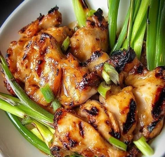 Vietnamese grilled chicken served on a plate with fresh herbs and spices