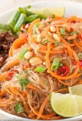A vibrant Spicy Glass Noodle Salad (Yam Wun Sen) garnished with fresh herbs and chili.