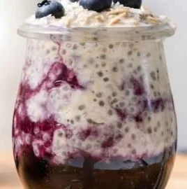 Bowl of blueberry overnight oats topped with fresh blueberries and almonds