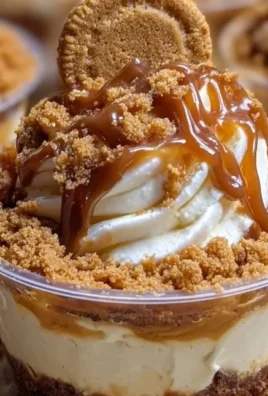 Delicious cookie butter cheesecake cups topped with whipped cream and cookie crumbles
