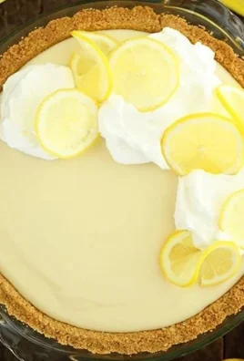 Slice of easy lemon cream pie with whipped cream topping and lemon zest garnish