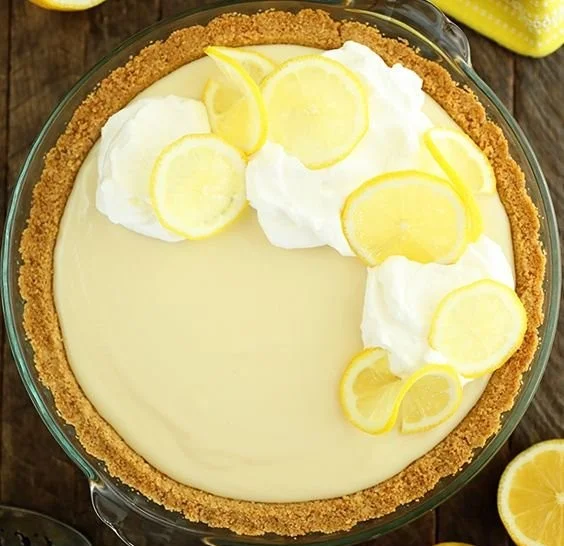 Slice of easy lemon cream pie with whipped cream topping and lemon zest garnish