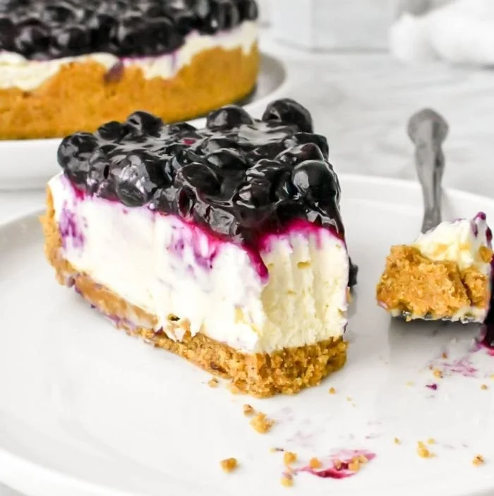 No bake blueberry cheesecake topped with fresh blueberries and cream