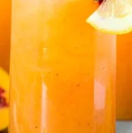 Refreshing Peach Lemonade served in a glass with fresh peaches and lemons