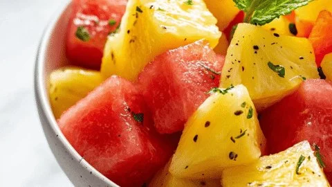 Refreshing watermelon and pineapple fruit salad served in a bowl.