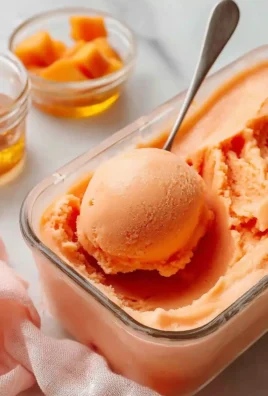 Delicious peach sorbet served in a bowl garnished with fresh peaches