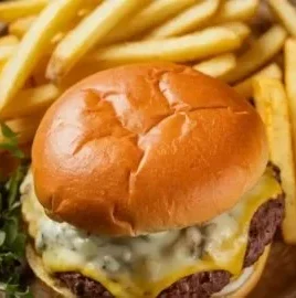 Delicious Blackstone smash burgers topped with caramelized onions on a grill.