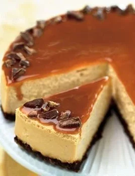 Delicious cheesecake topped with caramelized roasted pears on a white plate