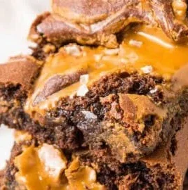 Decadent Biscoff brownies topped with caramel drizzle and chocolate chunks