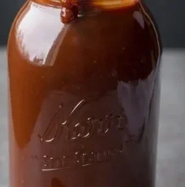 Homemade Kansas City BBQ Sauce in a jar on a rustic wooden table