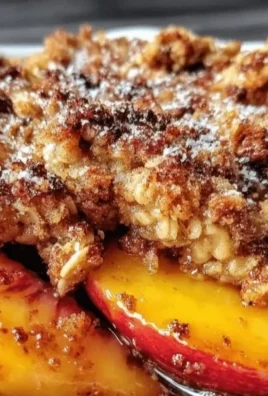 Bowl of easy homemade peach crisp topped with vanilla ice cream