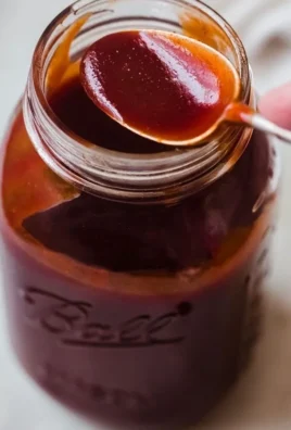 Homemade BBQ sauce in a jar with fresh ingredients around it