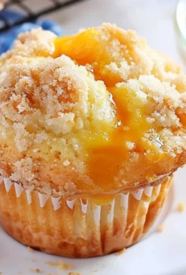 Delicious homemade peach cobbler muffins with fresh peaches and crumbly topping.