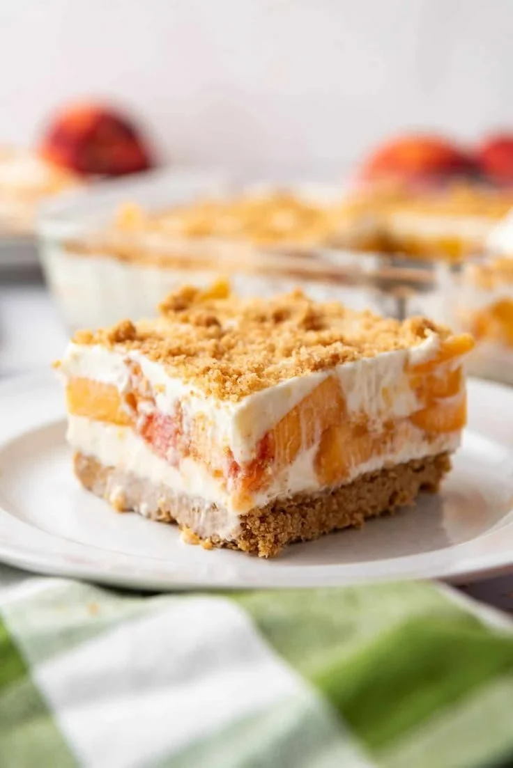 No-bake fresh peach dessert topped with whipped cream and mint leaves