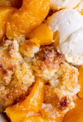 Freshly baked peach cobbler served in a dish with a golden crust