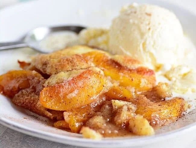Delicious homemade Peach Cobbler ready to serve with a golden crust.