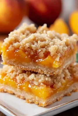 Freshly baked peach crumb bars with a golden crumb topping