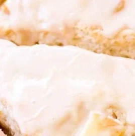 Delicious Peach Pie Scones topped with creamy vanilla glaze on a plate.