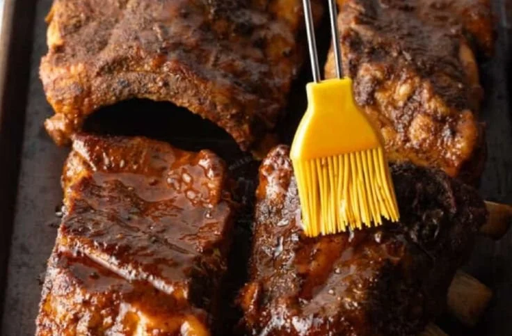 Delicious slow cooker ribs served with BBQ sauce on a plate