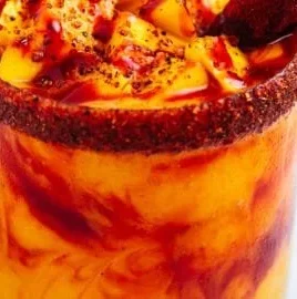 Delicious homemade mangonada topped with fresh mango and chili