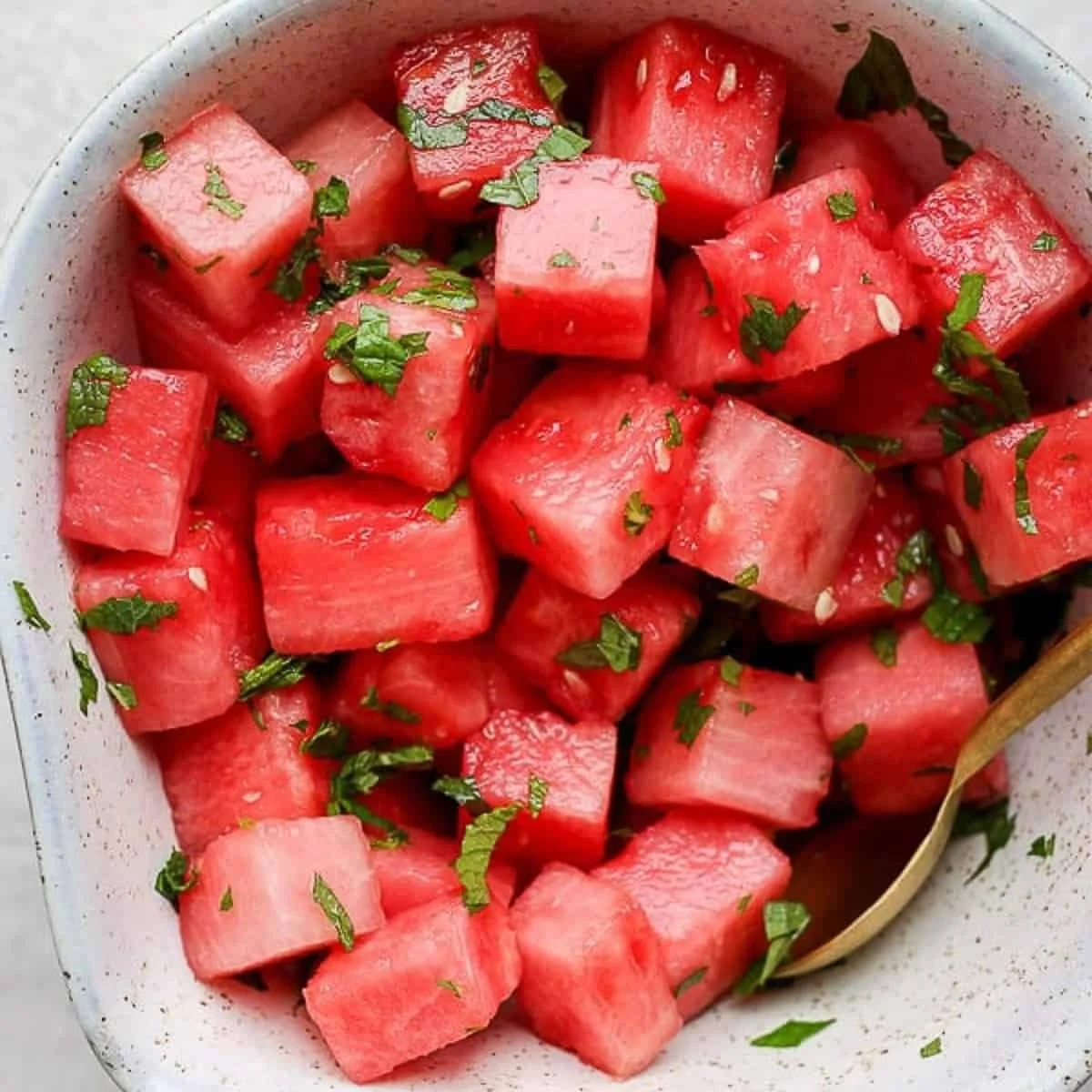 Vibrant watermelon mint salad served in a bowl with fresh mint leaves.