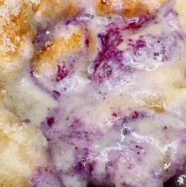 Blueberry jam protein baked oats dish with fresh blueberries on top