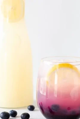 A refreshing glass of blueberry lemonade garnished with fresh blueberries and lemon slices.