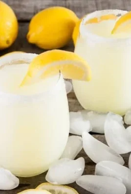 Refreshing boozy lemonade slushies in colorful glasses with fruit garnishes.