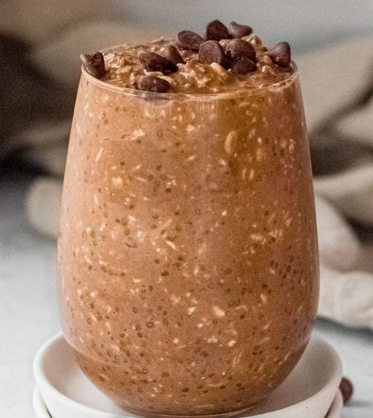 Bowl of chocolate overnight oats topped with fruits and nuts