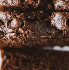 Moist chocolate zucchini bread with chocolate chips on a wooden table
