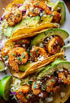 Cilantro lime shrimp tacos topped with creamy slaw on a wooden table