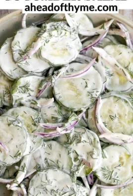 Creamy cucumber salad served in a bowl with fresh cucumbers and herbs