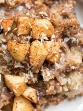 Healthy quinoa apple breakfast bowl topped with fresh fruits and nuts.