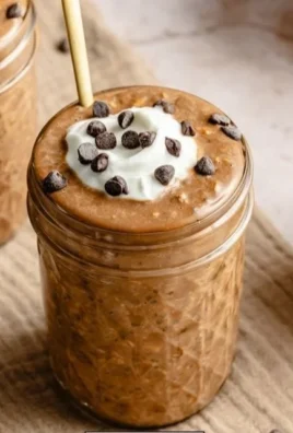 High protein coffee overnight oats served in a bowl with coffee beans and oats.