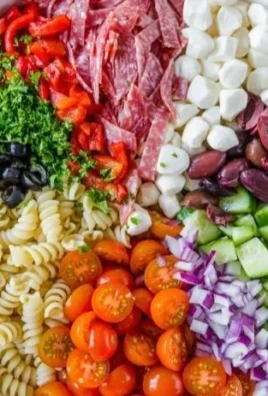 Colorful Italian pasta salad with fresh vegetables and dressing.