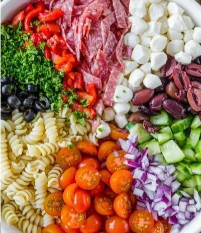 Colorful Italian pasta salad with fresh vegetables and dressing.