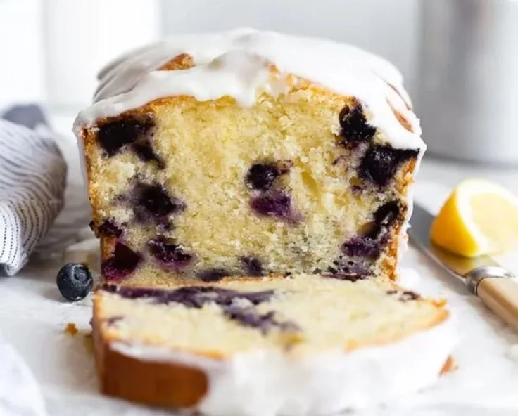 Sliced lemon blueberry pound cake with fresh blueberries and lemon zest