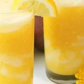 Freshly made Mango Lemonade served in a glass with a slice of lemon